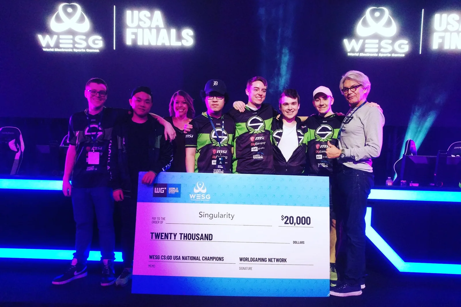Team Singularity WESG winners holding a 20,000 dollar cheque